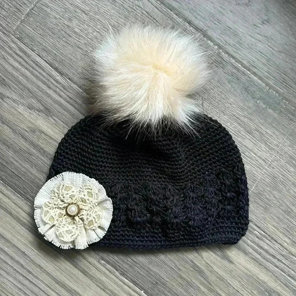Hand crafted black crochet girls hat with flower and fuzzy pom pom